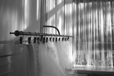 Dresses hanging on rack against window