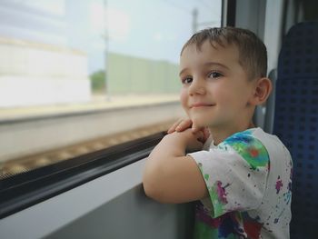 Side view of boy by window in train