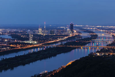 Illuminated bridge over river against sky at night