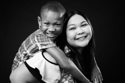 Portrait of smiling boy against black background