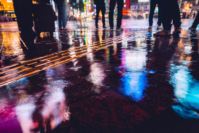 Low section of people walking on wet street during rainy season