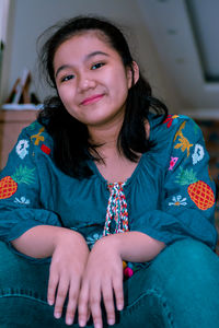 Portrait of smiling girl sitting on sofa at home