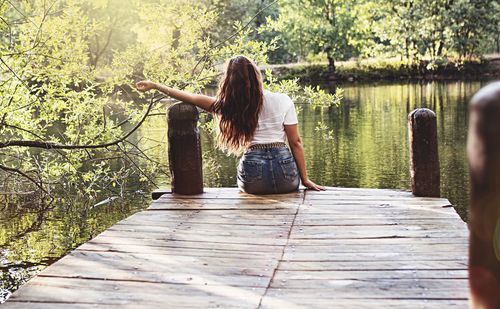Rear view of woman standing on boardwalk