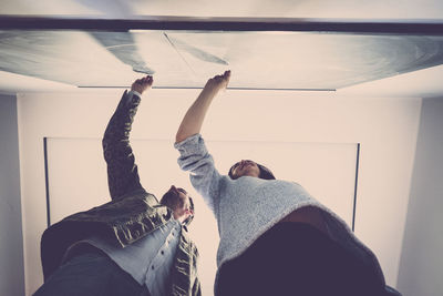 Low angle view of smiling colleagues writing on blackboard in office