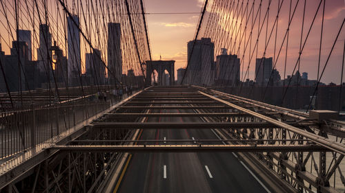 Bridge in city against sky during sunset