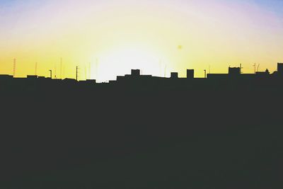 Silhouette cityscape against sky during sunset