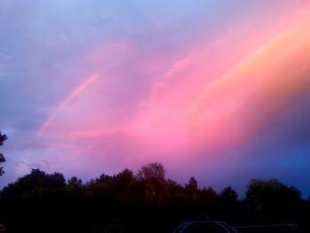 Scenic view of rainbow over landscape against cloudy sky