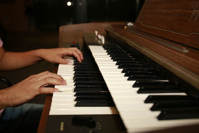 Midsection of man playing piano