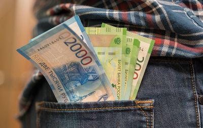 Midsection of man with paper currencies in back pocket