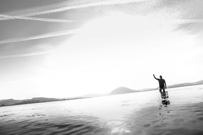 Man in sea against sky