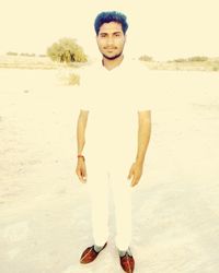Portrait of young man standing on beach