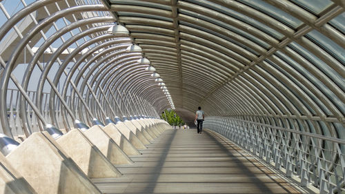 Rear view of people walking on footbridge