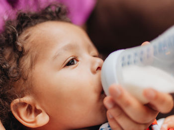 Close-up of cute boy drinking milk at home