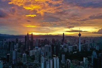 Aerial view of buildings in city during sunset