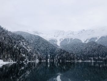 Scenic view of lake by snowcapped mountains against sky