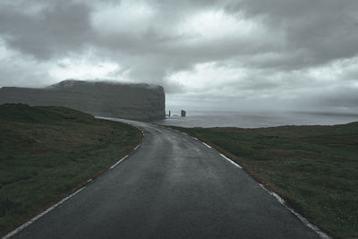 Road by mountain against sky