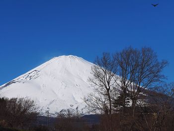 Scenic view of snowcapped mountains against clear blue sky