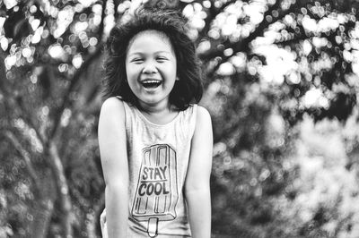 Portrait of smiling girl against trees