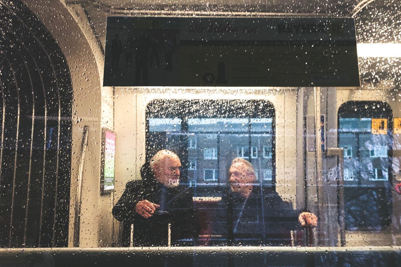 window, glass - material, real people, men, reflection, two people, architecture, transparent, adult, people, building exterior, built structure, lifestyles, day, males, women, city, communication, snowing, building, outdoors, couple - relationship