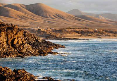 Scenic view of sea and mountains against sky