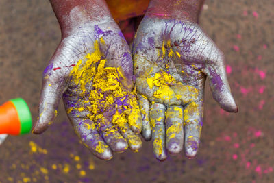 Cropped hands of person covered with powder paint