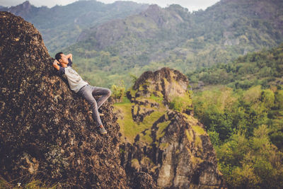 Side view of a man on rock