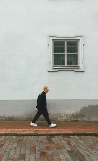 Side view of man looking through window on building