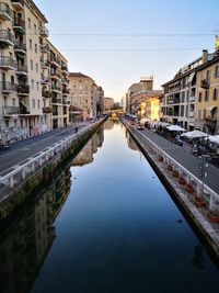 Canal amidst buildings against clear sky