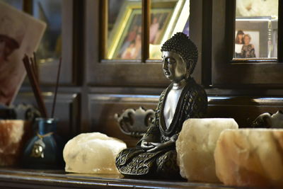 Close-up of buddha statue on table