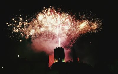 View of buildings with fireworks in sky at night