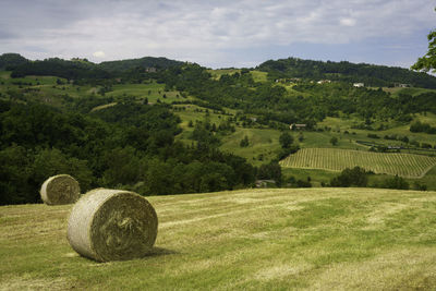 Hay bales on field against sky