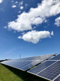 Solar panels on field against sky