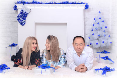 Family lying down against mantelpiece during christmas