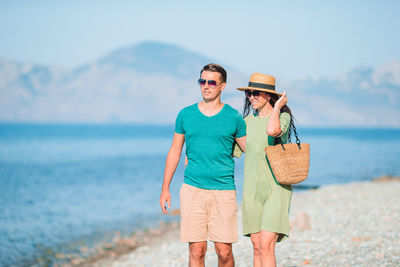 Full length of friends standing on beach