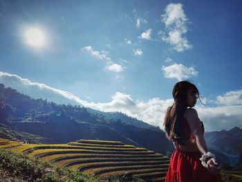 Woman standing on land against sky