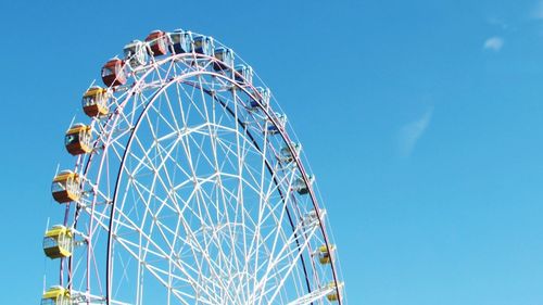 High section of ferris wheel against clear blue sky