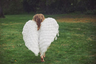 Rear view of woman standing on grassy field