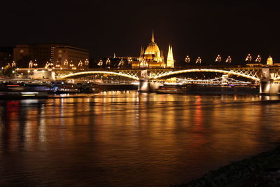 Illuminated bridge over river at night and the budapest parliament