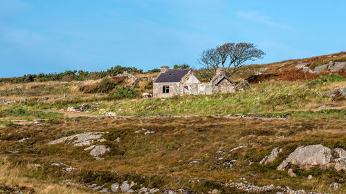 Abandoned house on field against sky