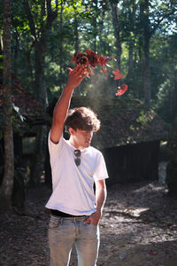 Full length of young man standing by tree