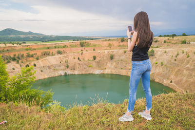 Full length of woman photographing on land