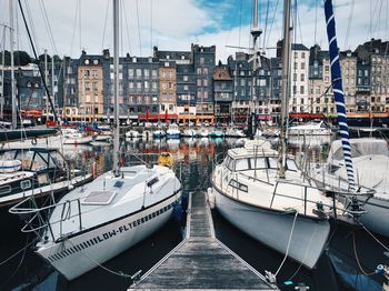 Boats moored at harbor by buildings in city