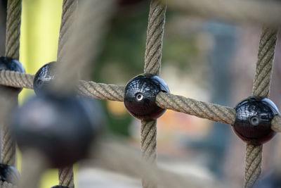 Close-up of rope tied up on metal chain