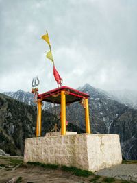 Traditional windmill on mountain against sky