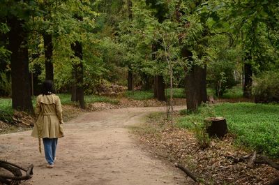 Rear view of woman walking on road