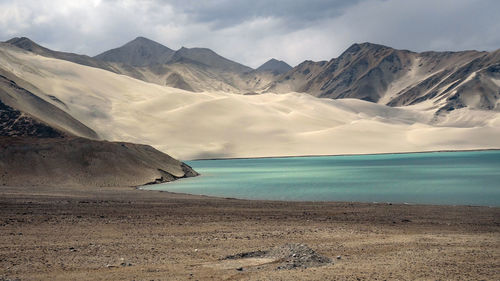 Scenic view of sea and mountains against sky