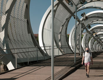 Rear view of woman walking on footpath