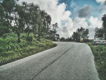 Empty road along trees