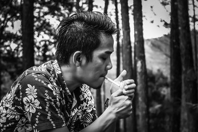 Side view of man smoking cigarettes