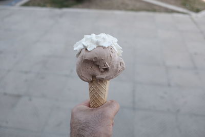 Close-up of hand holding ice cream cone outdoors